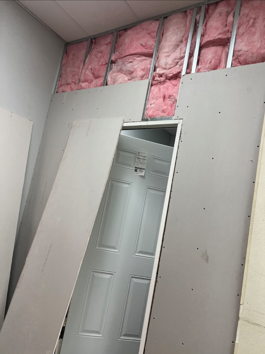 Drywall installation in progress with framing and insulation
